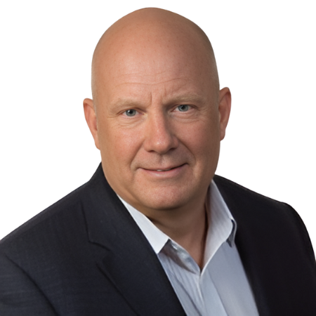 Professional headshot of AJ in a dark suit jacket and light shirt, smiling slightly